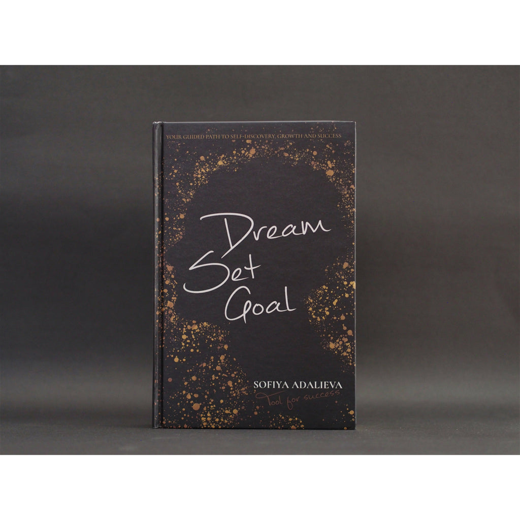 The front cover of Dream Set Goal | Tool for success written by Sofiya Adalieva with a additional title on the top of the cover stating "Your guided path to self-discovery, growth and success". The front cover has a silhouette of a human face and neck in profile - all in black and having golden drops all around it. The book is against a charcoal background.   